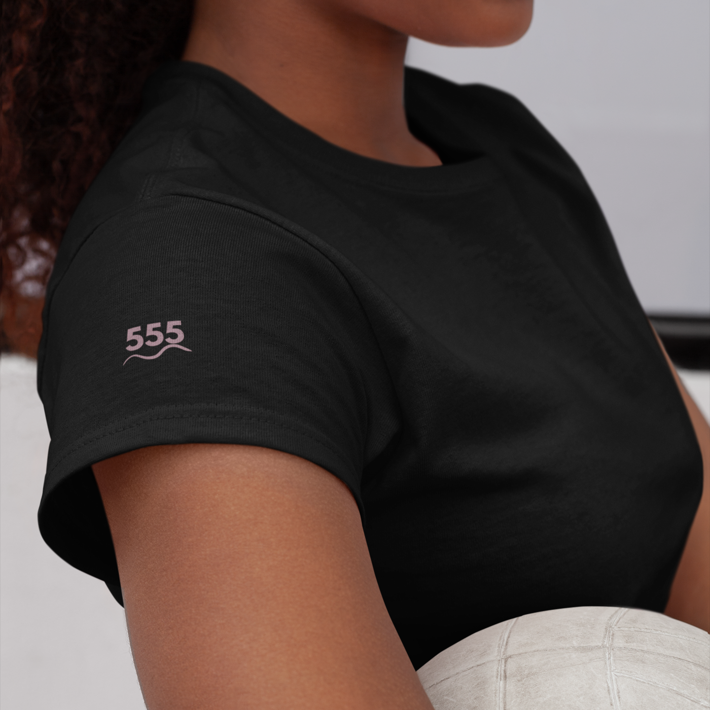 Black short sleeve tee in Eclipse with mauve 555 angel number printed on the sleeve — designed to embody freedom, energetic shift, and movement forward